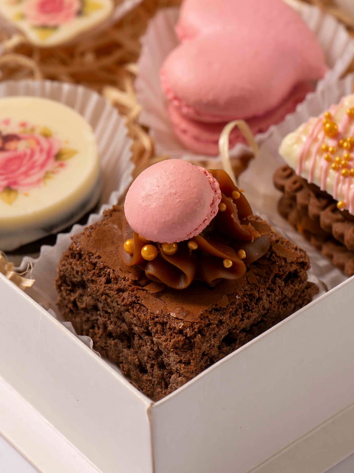 Un brownie con dulce de leche y un macaron rosa encima