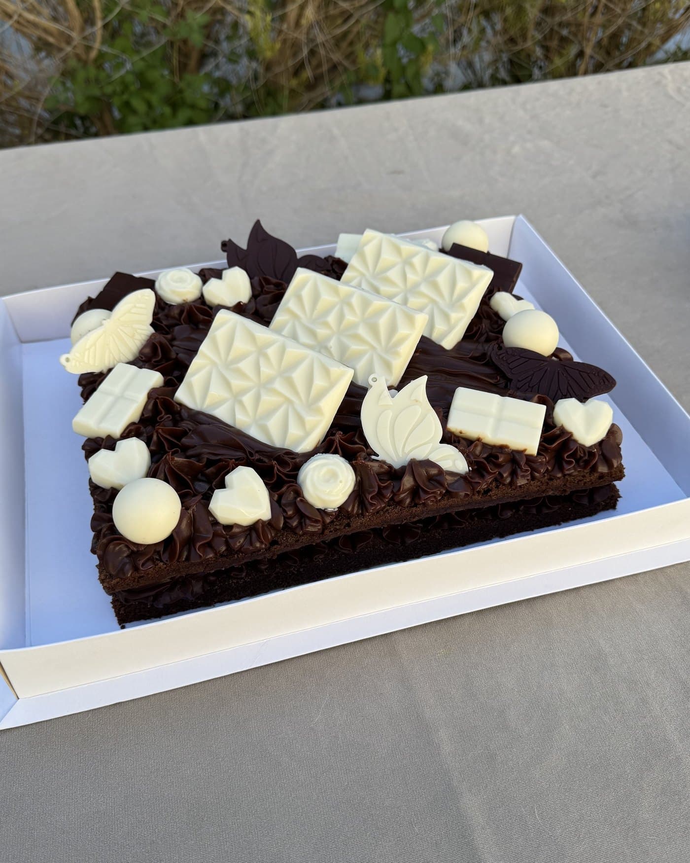 Torta Matilda de chocolate, con copetes de ganache y placas de chocolate blanco